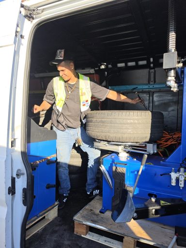 tire replacement in Hoboken NJ Happy road services in the work van installing a tire