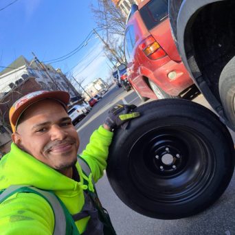 Luis from Happy Road Services Luis installing a spare tire on the side of the road in jersey city
