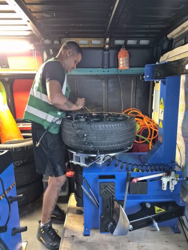 Tire change in Union City NJ — roadside technician installing a spare tire on Bergenline Avenue